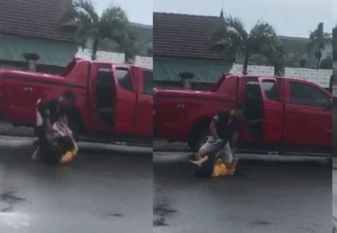 Người phụ nữ bị đánh đập dã man cạnh chiếc ô tô bán tải màu đỏ. Ảnh Cắt từ clip