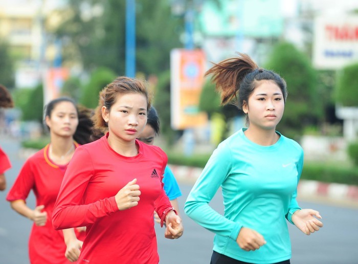 Nguyễn Thị Oanh (áo đỏ) rèn luyện để tranh tài trên đường chạy báo Tiền Phong. (Trong ảnh, Oanh chuẩn bị thi tài giải năm 2019). Ảnh: Xuân Tùng