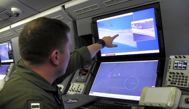 Một quân nhân Mỹ trên máy bay giám sát P-8A Poseidon xem màn hình máy tính cho thấy hoạt động xây dựng của Trung Quốc trên Đá Chữ Thập thuộc quần đảo Trường Sa của Việt Nam. Trung Quốc đã chiếm đóng và cải tạo trái phép thực thể này.