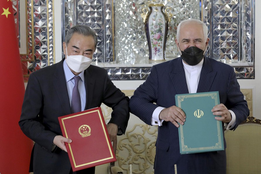 Bộ trưởng Ngoại giao Iran Mohammad Javad Zarif, bên phải, và người đồng cấp Trung Quốc Vương Nghị, chụp ảnh sau buổi lễ ký kết các văn kiện, tại Tehran, Iran, hôm 27/3. | Ebrahim Noroozi / AP