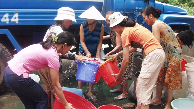 Không ít nơi tại Hà Nội chưa có đường ống dẫn, thiếu nước sạch phải có xe chở tới cấp cho người dân (Ảnh chụp tại Định Công, Hoàng Mai, Hà Nội). Ảnh: Hồng Vĩnh 