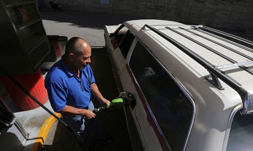 Henry Duran, một người dân Venezuela đang đổ đầy xăng cho chiếc Ford LTD Ranger sản xuất năm 1978 tại Caracas, Venezuela. Ảnh: AP