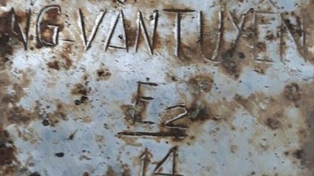 Tấm nhôm khắc tên "NG-VĂN-TUYÊN E2/14” nằm cùng hài cốt liệt sĩ.