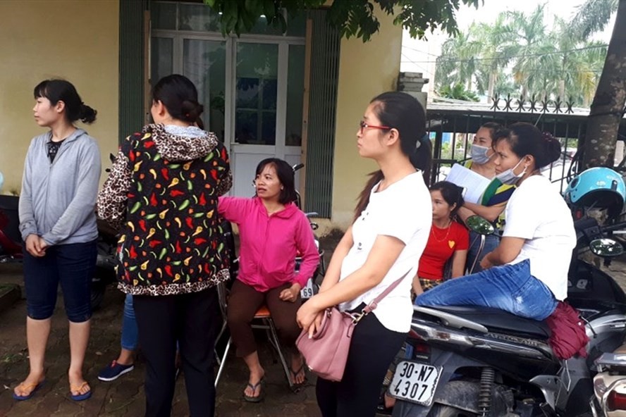Giáo viên hợp đồng tập trung cạnh UBND huyện Thanh Oai để chờ lời giải thích thỏa đáng từ lãnh đạo huyện. Ảnh: Đình Tuệ/ Lao Động 