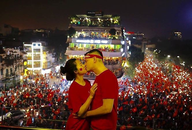 Nụ hôn ngày chiến thắng. Đôi vợ chồng Quyên và David trao nhau nụ hôn nhau trong đám đông ăn mừng chiến thắng của U23 Việt Nam! (Ảnh: Như Ý)