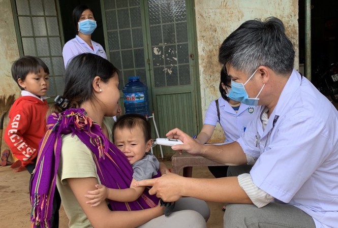 Các bác sỹ đo thân nhiệt cho các em nhỏ ở huyện Đắk Đoa