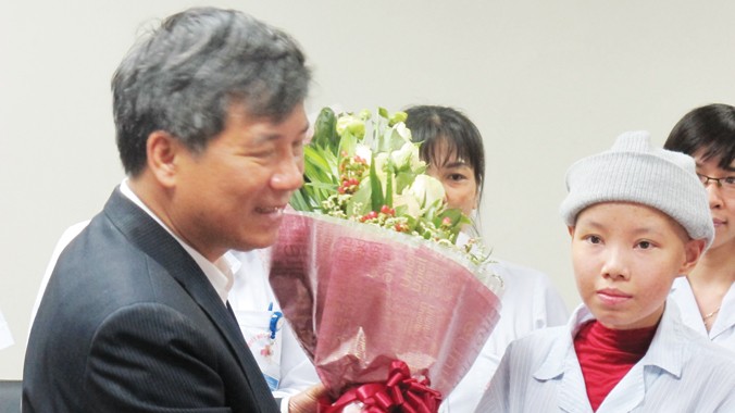 GS.TS Nguyễn Anh Trí tặng hoa cho bệnh nhân Linh (bên phải). Ảnh: T.Hà.