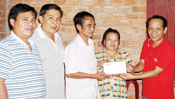 Vợ chồng ông Huỳnh Văn Nén nhận tiền hỗ trợ của Thuduc House.