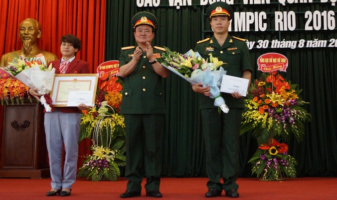 Trung tướng Trần Đơn, Thứ trưởng Bộ Quốc phòng (giữa) trao thưởng cho hai VĐV Hoàng Xuân Vinh và Văn Ngọc Tú, sáng 30/8. Ảnh: Nguyễn Minh.