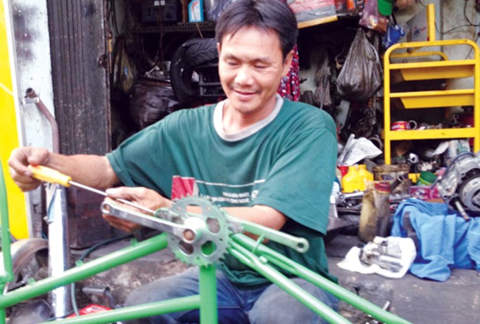 Anh Lê Văn Thái lắp ráp xe đạp cũ tặng người nghèo. Ảnh: Trọng Thịnh.