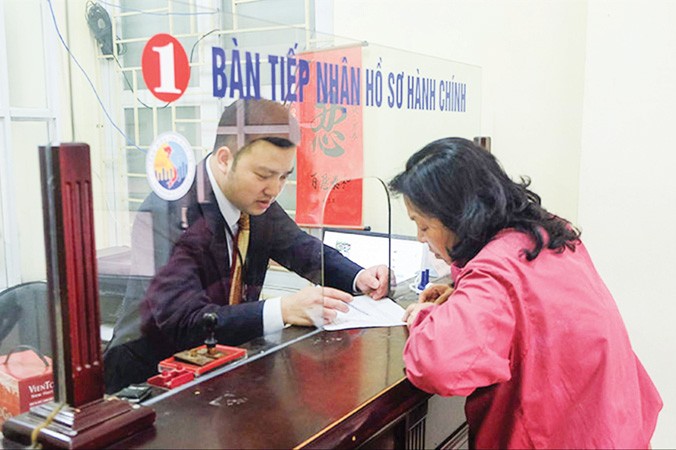Cán bộ hướng dẫn người dân làm thủ tục tại UBND phường Phương Liên (quận Đống Đa).
