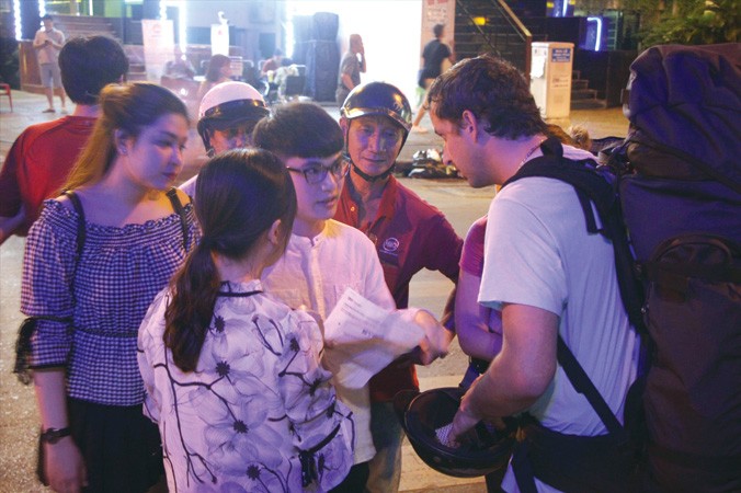 Nhóm bạn trẻ giúp du khách nước ngoài tìm đường đi tại TPHCM. Ảnh minh họa: Ngô Tùng.