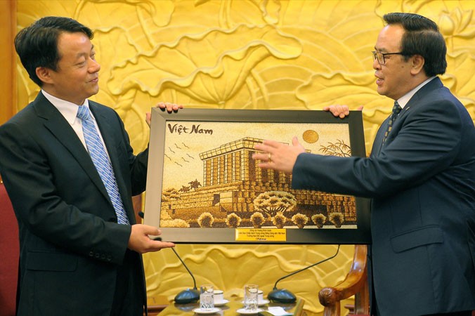 Trưởng Ban Ðối ngoại Trung ương Hoàng Bình Quân tặng quà cho đoàn đại biểu TNCS Trung Quốc. Ảnh: Xuân Tùng.