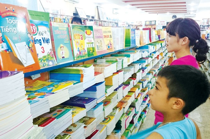 Phụ huynh cùng con lựa chọn mua sách giáo khoa tại một hiệu sách ở Hà Nội. Ảnh: Ngọc Châu.