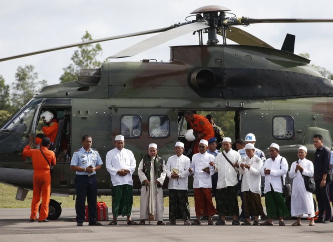 Các giáo sĩ Hồi giáo cầu nguyện trước khi lên trực thăng của quân đội Indonesia để tới hiện trường vụ máy bay rơi và cầu nguyện cho các nạn nhân - Ảnh: Reuters