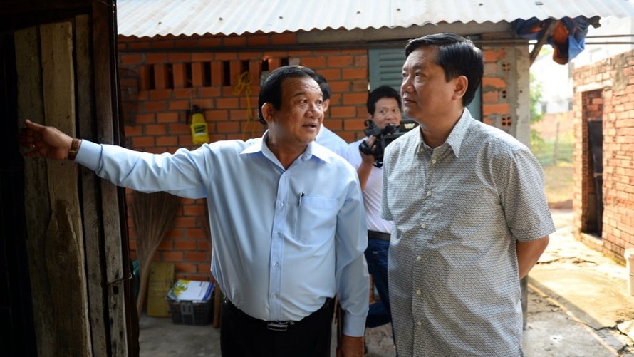 Ông Đinh La Thăng đi thăm căn nhà của bà Oanh và yêu cầu lãnh đạo Củ Chi sớm sửa lại nhà đã xuống cấp cho bà. Ảnh: Tuổi Trẻ