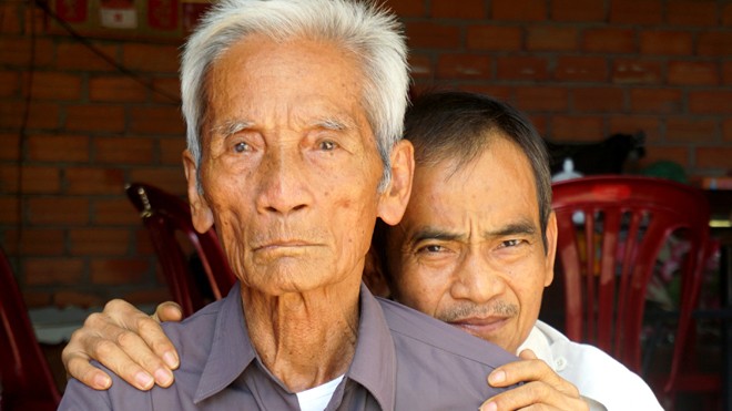 Đã 92 tuổi, cụ Huỳnh Văn Truyện (phía trước) vẫn chưa thể dừng lại trên con đường mang lại công lý cho con trai mình, ông Huỳnh Văn Nén (phía sau).