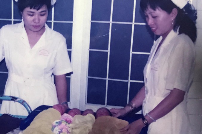 Các nữ hộ sinh chụp ảnh với 4 trẻ sơ sinh tại bệnh viện.