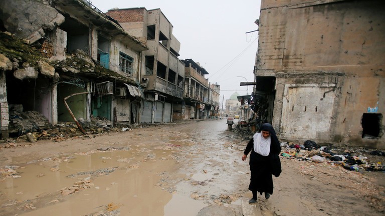 Một người phụ nữ di chuyển khó nhọc trong thành phố Mosul tan hoang