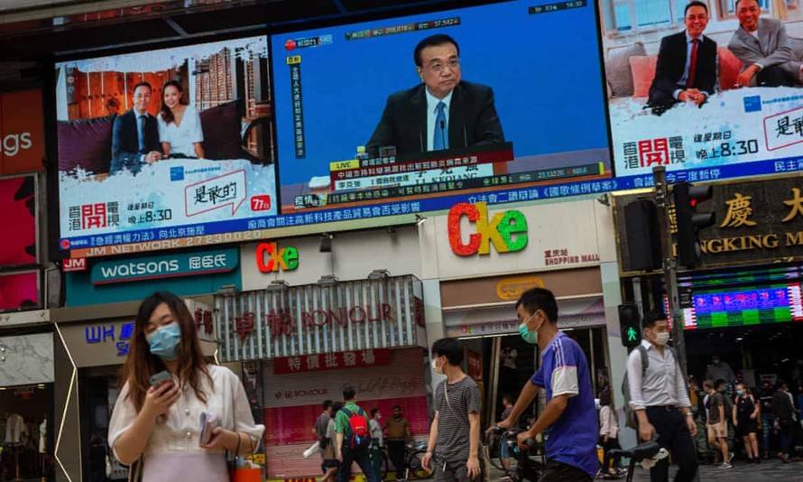 Người dân Hong Kong theo dõi cuộc họp báo của Thủ tướng Lý Khắc Cường về dự luật an ninh mới. Ảnh: EPA.