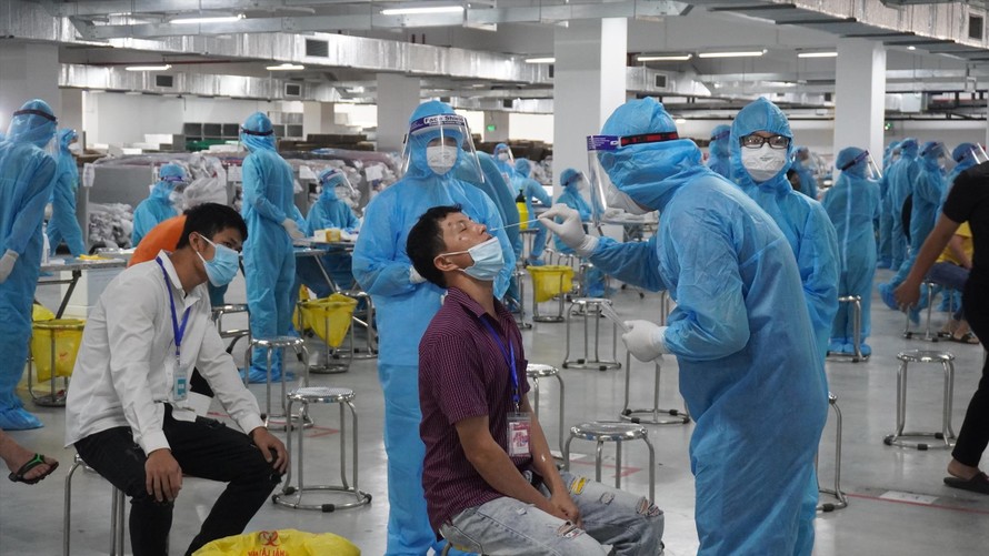 Cán bộ y tế của tỉnh Quảng Ninh lấy mẫu xét nghiệm cho công nhân ở Bắc Giang