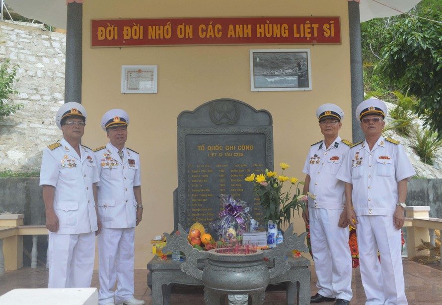 Các CCB tàu C235 Lê Duy Mai, Hà Minh Thật, Lâm Quang Tuyến, Nguyễn Hồng Phong trước tấm bia ghi danh các đồng đội liệt sĩ tàu C235 tại Khu di tích lịch sử Quốc gia Hòn Hèo. Ảnh: KIẾN NGHĨA 