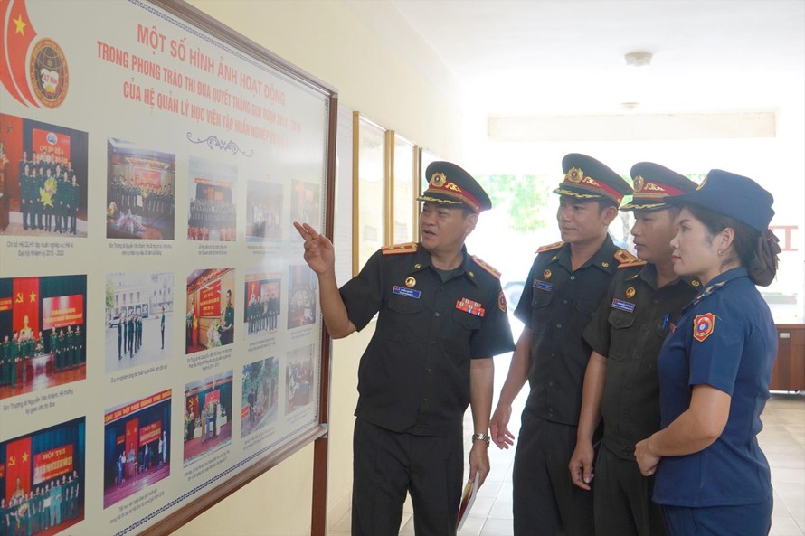 Trung tá Thanih Bounnao (ngoài cùng bên trái) cùng một số thành viên trong đoàn sĩ quan trẻ Lào trao đổi sau một buổi tập huấn tại Đoàn 871, Tổng cục Chính trị QĐND Việt Nam. ẢNH: NGUYỄN MINH