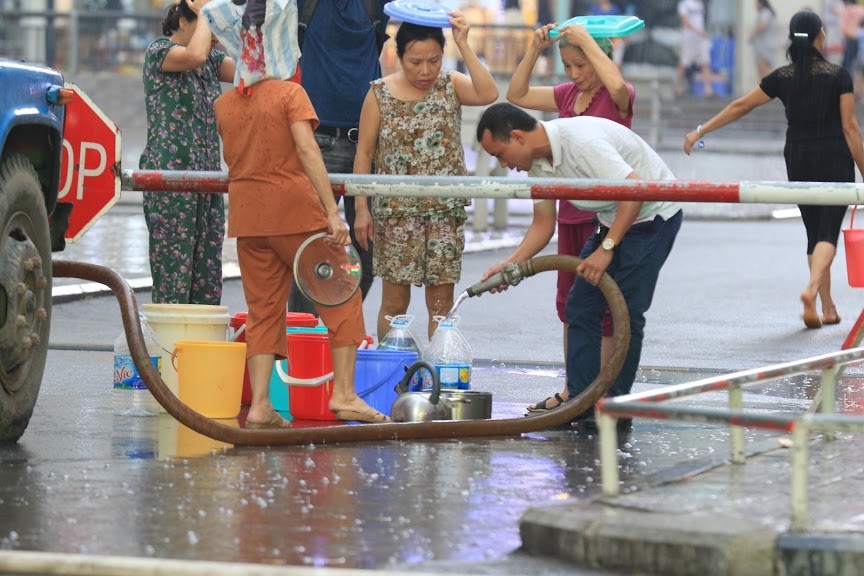Người dân chung cư Linh Đàm khổ sở lấy nước sạch trong đợt nhà máy nước sông Đà nhiễm dầu bẩn. Ảnh: Như Ý