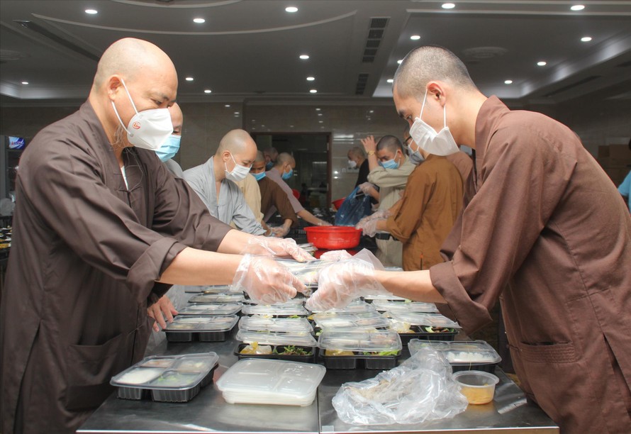  Thượng tọa Thích Thanh Phong (bìa trái), Trụ trì chùa Vĩnh Nghiêm chuẩn bị phần ăn gửi tặng các lực lượng chống dịch. Ảnh: NGÔ TÙNG
