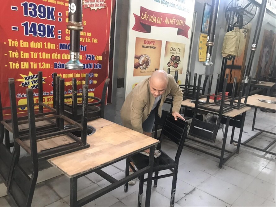 Anh Nguyễn Hoàng - chủ quán buffet 123 Nướng ngon lau dọn bàn ghế do chưa tìm được lao động Ảnh: U.P
