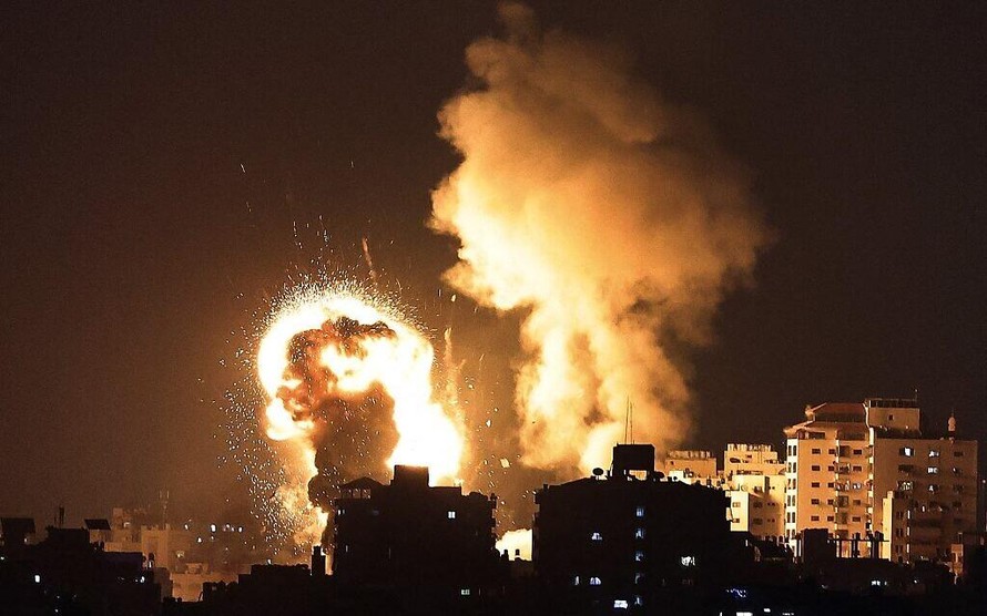 Cột lửa khổng lồ làm sáng rực bầu trời Dải Gaza sau một cuộc không kích của Israel đêm 10/5. Ảnh: AP 