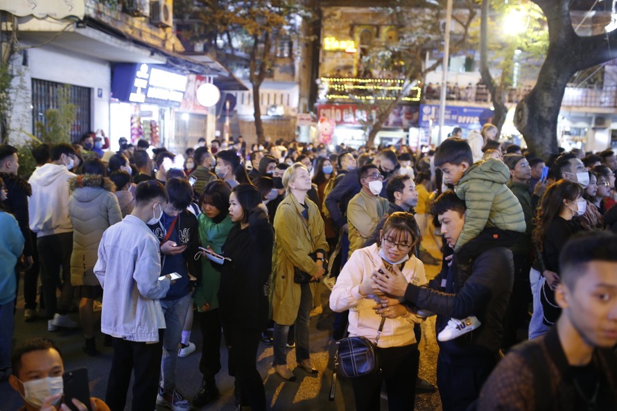 Tối 24/12, nhiều người đi chơi Giáng sinh chủ quan không đeo khẩu trang nơi công cộng tại quận Hoàn Kiếm, Hà Nội. Ảnh: Như Ý