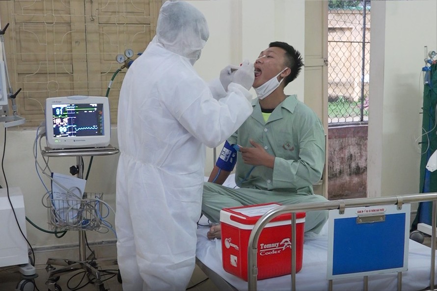Trung tá, bác sĩ Nguyễn Đức Đồng thăm khám cho bệnh nhân nghi mắc COVID-19 Ảnh: PV 