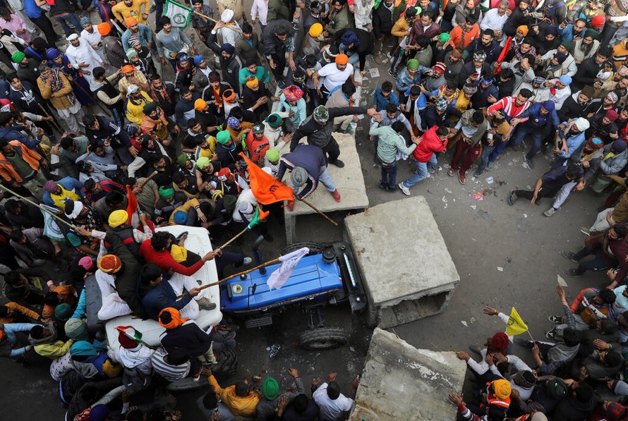 Nông dân Ấn Độ đang cố tháo dỡ chướng ngại vật khi biểu tình ngày 26/1.Ảnh: Reuters 