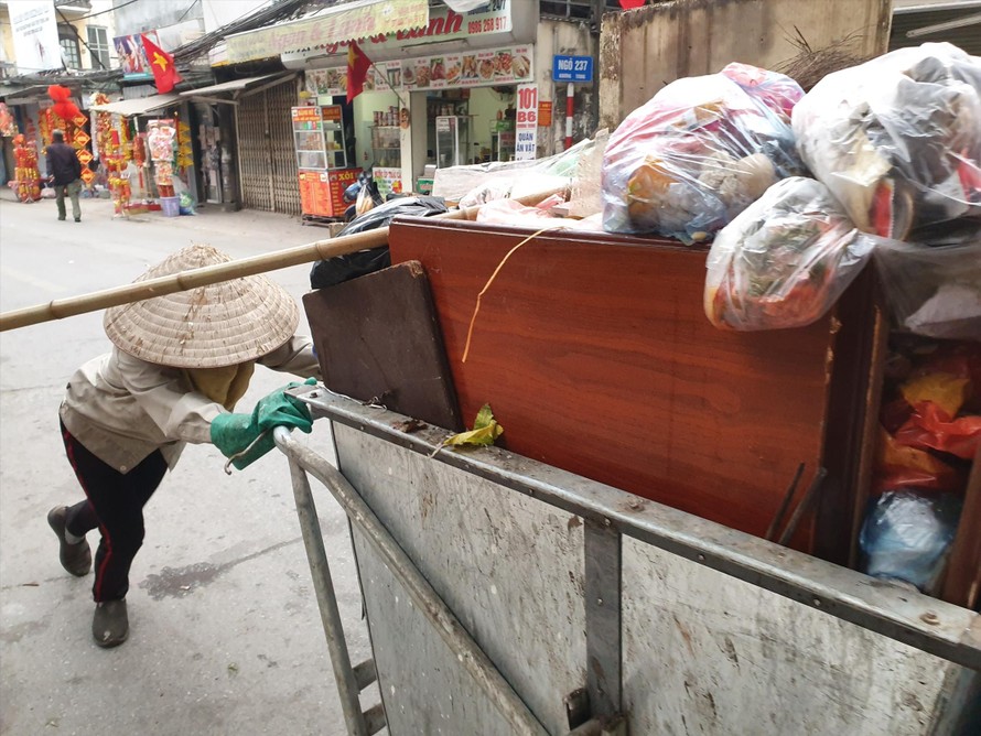 Công nhân môi trường chật vật dọn rác ngày cuối năm. (Ảnh chụp tại phố Khương Trung và phố Chùa Láng, Hà Nội) 