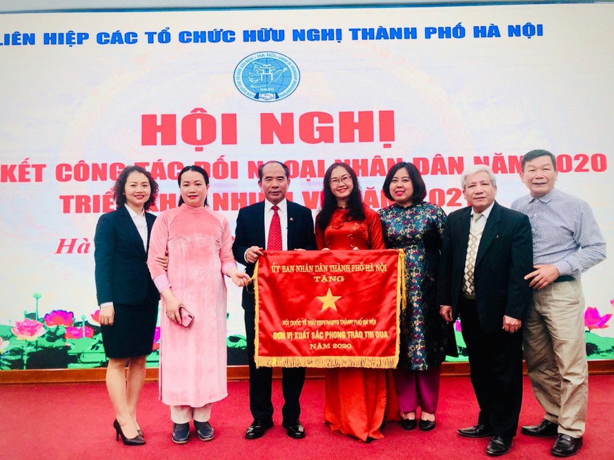 Chị Phương Mai và chị Trịnh Huyền (thứ 4, thứ 5 từ trái sang) nhận cờ thi đua từ UBND TP Hà Nội 