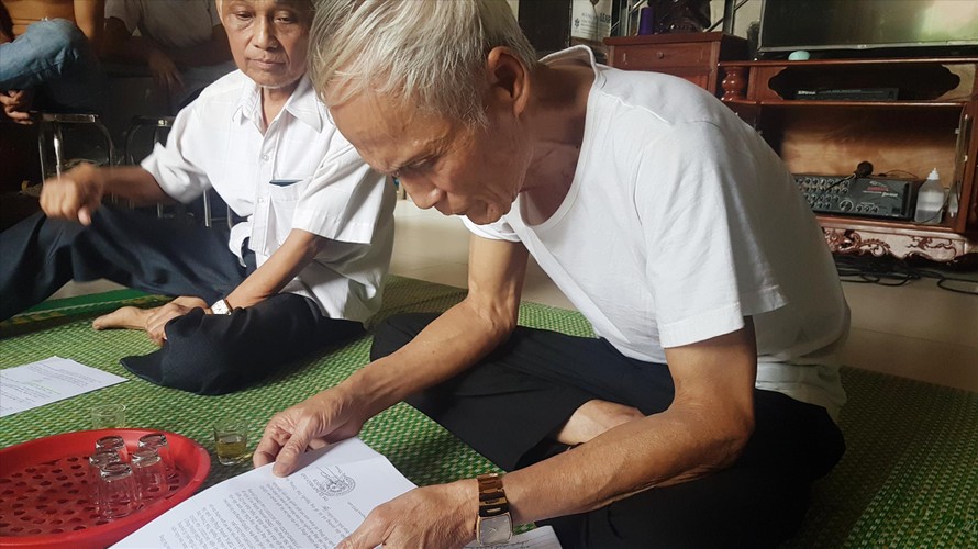 Ông Nguyễn Thái Tưởng lật giở từng trang giấy kể lại chuyện 40 năm của xóm 