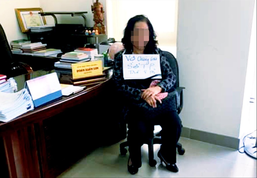 Một phụ nữ cầm biển đòi nợ tại phòng làm việc của Giám đốc Sơn 