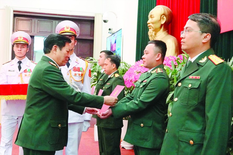 Đại tướng Ngô Xuân Lịch trao quyết định thăng quân hàm trước niên hạn, tuyển dụng quân nhân chuyên nghiệp cho 4 GMTTB toàn quân, sáng 17/3. Ảnh: Nguyễn Minh
