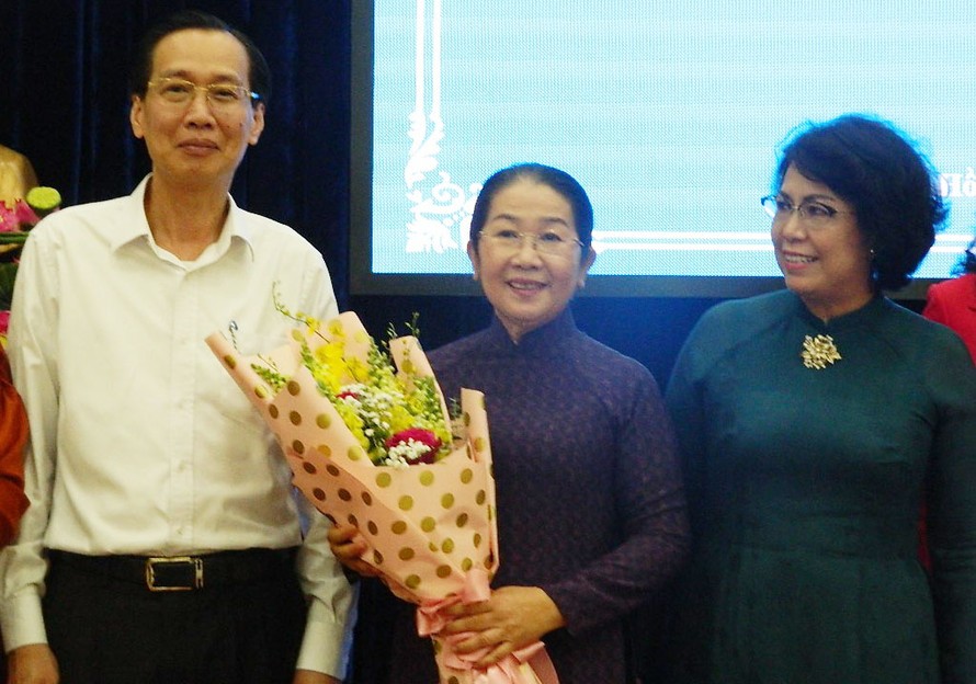 Phó Chủ tịch thường trực UBND TPHCM Lê Thanh Liêm và Chủ tịch Ủy ban MTTQ TPHCM Tô Thị Bích Châu (bìa phải) tặng hoa và chụp ảnh lưu niên với bà Võ Thị Dung 