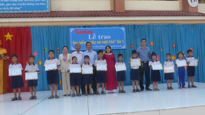 Các em học sinh nhận học bổng chụp hình chugn với baó Tiền Phong và Ban giám hiệu nhà trường.