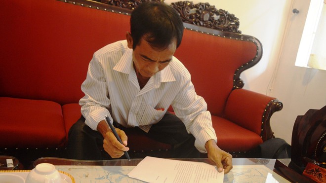 Ông Huỳnh Văn Nén kí tên vào đơn tố cáo bổ sung vào chiều 3/3. Ảnh: Ngô Bình