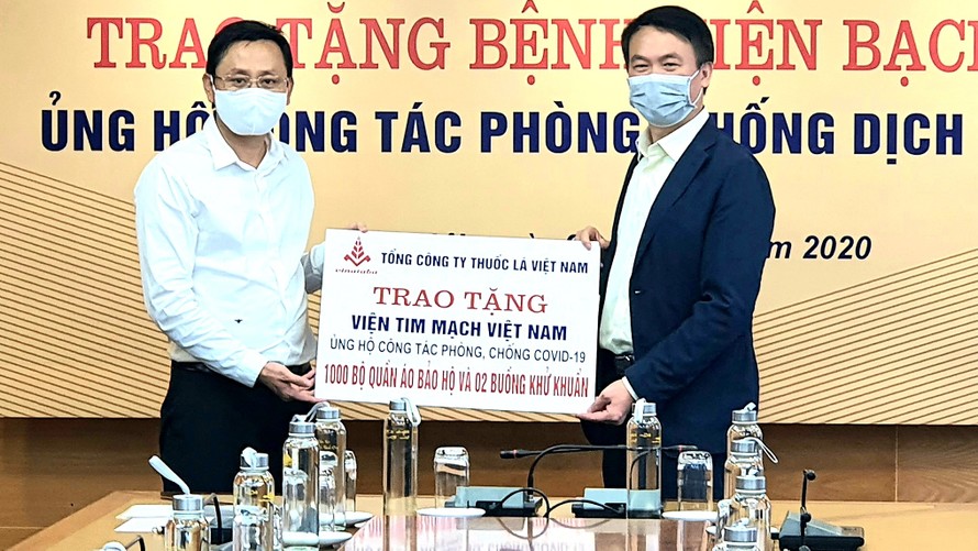 Ông Hồ Lê Nghĩa (bên trái)trao tặng tiền ủng hộ bệnh viện chống covid 19