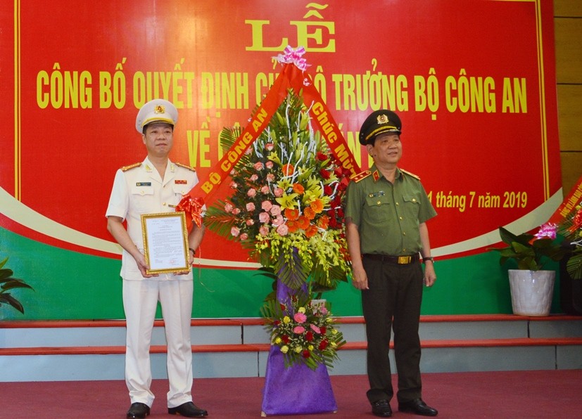 Trung tướng Nguyễn Văn Sơn, Thứ trưởng Bộ Công an trao quyết định và tặng hoa chúc mừng Đại tá Trần Hải Quân