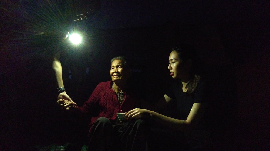 Chủ tịch TP Quảng Ngãi bật điện thoại lấy ánh sáng cho Nguyễn Thúc Thùy Tiên trao tiền cứu trợ người dân bị sập nhà ở Quảng Ngãi, tháng 1/2020. Ảnh: Trần Tuấn