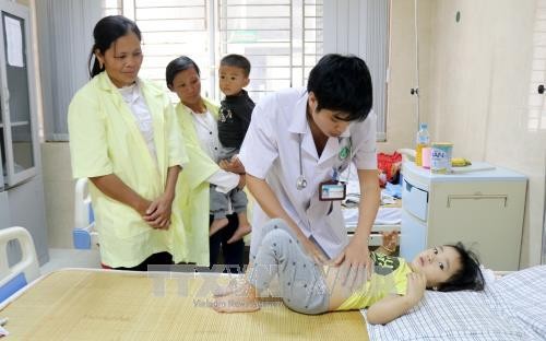 Bác sĩ Trung tâm Y tế huyện Cẩm Khê thăm khám cho cháu Nguyễn Khánh Ly, 3 tuổi, ở khu 4 xã Hương Lung. Ảnh: Trung Kiên - TTXVN