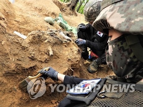 Các binh sĩ khai quật hài cốt được cho là của một binh sĩ Hàn Quốc thiệt mạng trong Chiến tranh Triều Tiên 1950-1953 tại Khu phi quân sự ở Cheorwon, tỉnh Gangwo. Ảnh: Yonhap