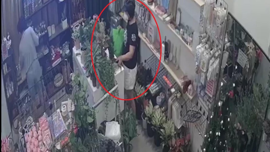 Người phụ nữ lấy trộm điện thoại của chủ cửa hàng.