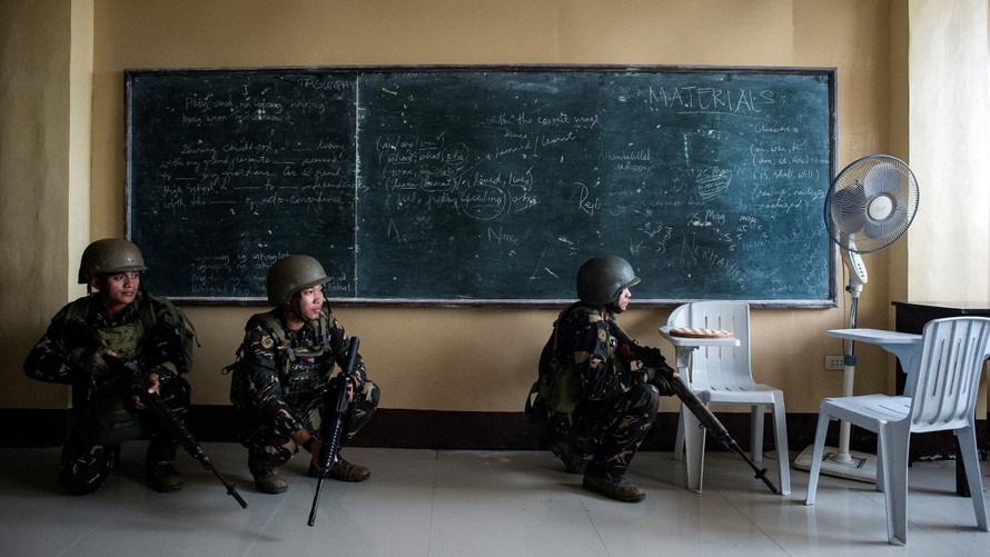 Binh lính Philippines giấu mình trong một lớp học để theo dõi nhóm phiến quân Maute hôm qua, 7/6. Ảnh: AFP
