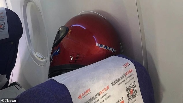 Hành khách nam đội mũ bảo hiểm lên máy bay vì sợ lây corona virus. Ảnh: Daily Mail